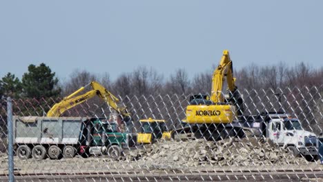 Bagger-Belädt-Einen-LKW-Mit-Erde-Auf-Der-Baustelle