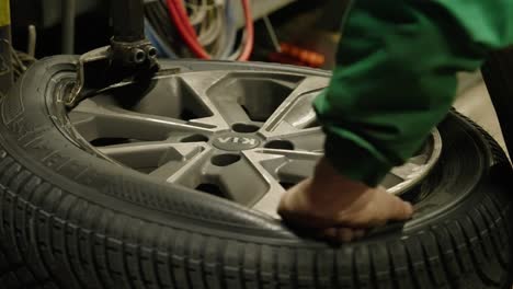 Close-up-of-repairman-which,-by-means-of-a-mechanical-arm,-mounts-tire-on-its-rim