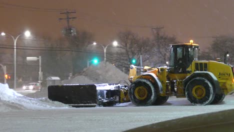 Snow-plow-with-very-large-mounted-snow-grader-working-at-night-in-parking-lot