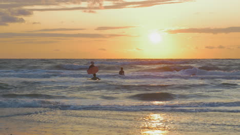 Grand-mother-is-body-surfing-with-two-grand-children-during-sunset-in-the-North-sea-in-The-Netherlands