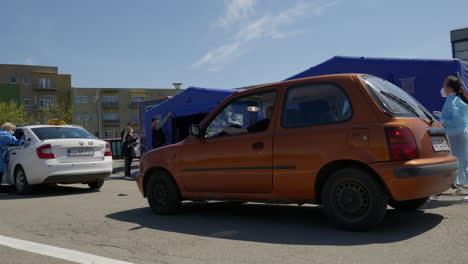 Weite-Aufnahme-Von-Menschen,-Die-Geduldig-Darauf-Warten,-Im-Zweiten-Drive-Through-Impfzentrum-Für-Covid-19-In-Rumänien-An-Der-Reihe-Zu-Sein,-Um-Den-Pfizer-Biontech-Impfstoff-Zu-Erhalten