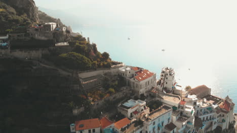 Aéreo,-Inclinado-Hacia-Arriba,-Disparo-De-Drone,-Sobre-Un-Hermoso-Pueblo-En-El-Sur-De-Italia,-Revelando-La-Puesta-De-Sol,-En-Un-Día-Soleado-De-Verano,-En-La-Costa-De-Amalfi,-Italia