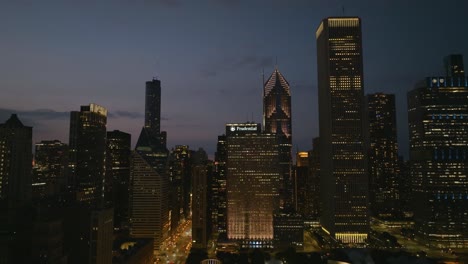 Aerial-view-in-front-of-illuminated-skyscrapers-in-the-New-Eastside-of-Chicago,-USA---tracking,-drone-shot