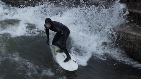 Toma-En-Cámara-Lenta-De-Un-Surfista-Surfeando-Una-Ola-Artificial-En-El-Río-Munich-Alemania