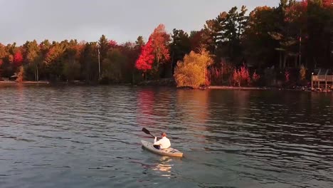 Kayaker-paddlinhg-along-Lake-Michigan-shoreline-during-autumn