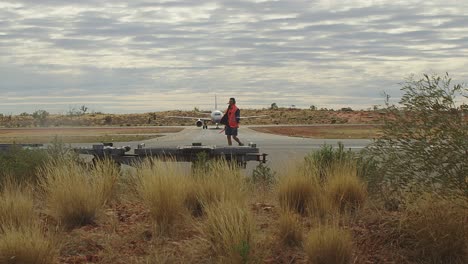 Ground-crew-at-an-outback-airport-prepare-for-the-arrival-of-a-taxiing-aircraft