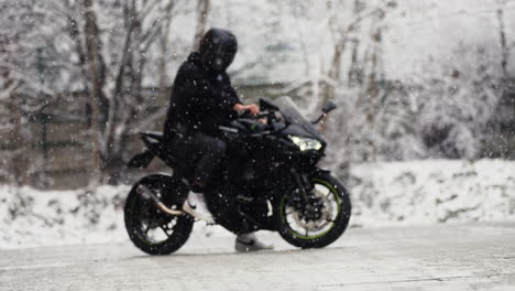 Motorcyclist-Rider-on-Black-Kawasaki-Motorcycle-Before-Starting-During-Winter-Snowy-Day,-Motorsport-Passion-and-Adventure