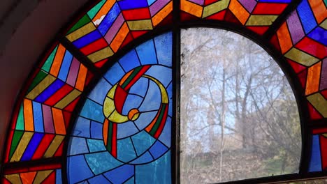 Arched-window-with-antique-stained-glass-in-historic-building,-Yerevan,-Armenia