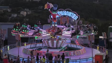 people-get-excited-on-the-jumping-and-swinging-lit-machine-at-carnival-fun-fair-in-Lugo,-Spain