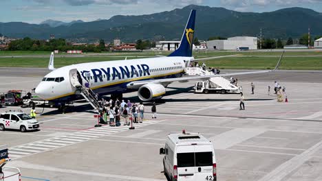 Passengers-boarding-on-a-Ryanair-plane-at-Bergamo-Airport,-Italy-during-sunny-summer-day