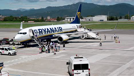 Passagiere,-Die-An-Einem-Sonnigen-Sommertag-Am-Flughafen-Bergamo,-Italien,-In-Ein-Ryanair-Flugzeug-Einsteigen