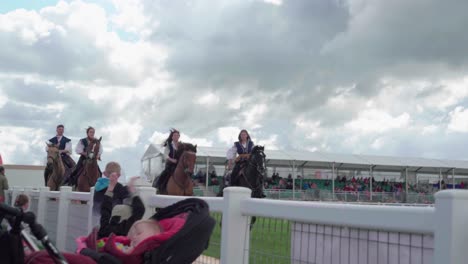 Grupo-De-Mujeres-Jóvenes-Que-Muestran-Habilidades-Para-Montar-A-Caballo-Durante-El-Espectáculo-Royal-Cornwall-2019-En-Wadebridge,-Cornwall,-Reino-Unido---Tiro-De-Seguimiento