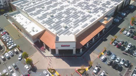 people-bustle-in-and-out-of-Costco,-going-about-their-shopping,-in-this-stunning-drone-time-lapse-video