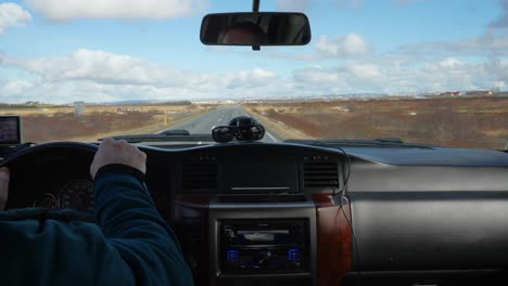 Pov-shot-of-man-driving-with-car-exploring-beautiful-landscape-of-Iceland-during-sunny-day-in-winter