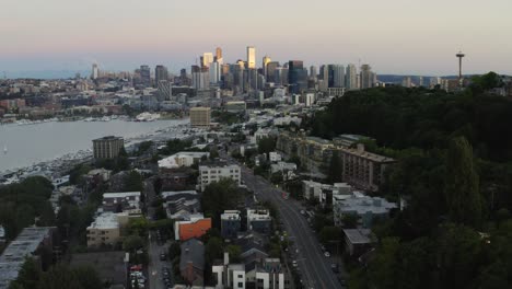 Revealing-aerial-of-distant-city-Seattle-and-icon-landmark-Space-Needle,-tilt-up