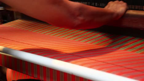 workers-weaving-thread-into-cloth-using-traditional-looms,-low-light-video-in-a-dark-room
