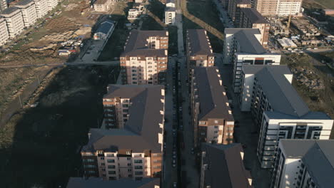 Cinematic-aerial-revealing-shot-over-many-symmetrical-buildings-and-worksites-in-an-unfinished-building-complex-4K