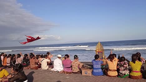 Balinese-culture,-praying-sitting-on-the-beach-in-front-of-the-ocean,-funeral-blessing-ceremony