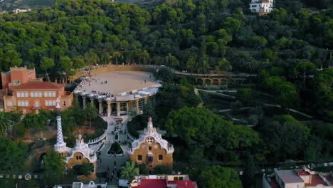 Aerial-view-over-the-Parc-Guell-park,-UNESCO-World-Heritage-Site,-in-Barcelona,-sunny-evening,-Spain---dolly,-drone-shot