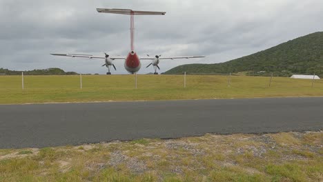 Low-angle-of-a-departing-turbo-propeller-commuter-aircraft-with-strong-propeller-wash-shaking-camera