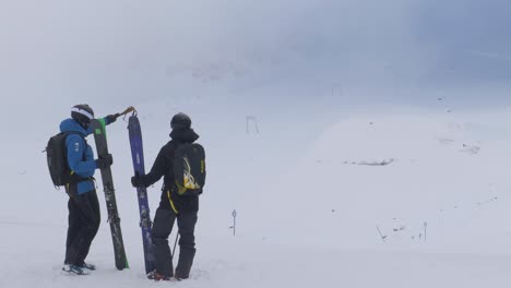 Skiers-planning-their-slalom-route,-high-up-in-the-foggy-Kaunertal-alps,-Austria