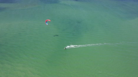Kite---Wind-Surfer-Soars-across-Turquoise---Blue---Green-Ocean-Waters-off-the-coast-of-Fuzeta