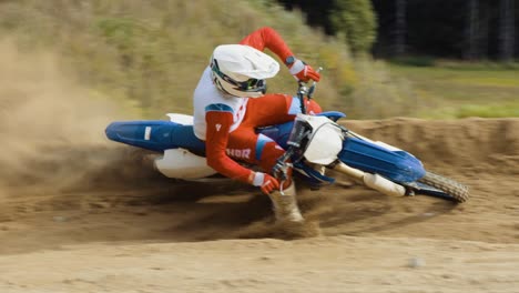 Motocross-Fahrer-Fährt-Hart-In-Zeitlupe-Durch-Eine-Steilkurve-Im-Sand