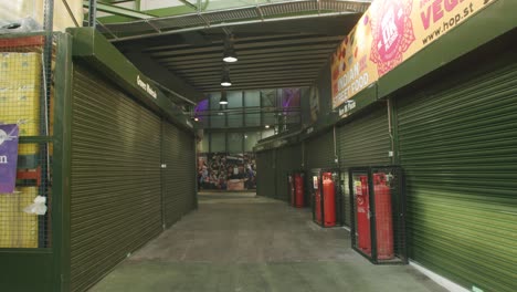 Lockdown-in-London,-empty-gimbal-walk-through-deserted-Borough-Market-with-wholesale-stores-closed-and-the-shutters-down,-during-2020's-COVID-19-pandemic