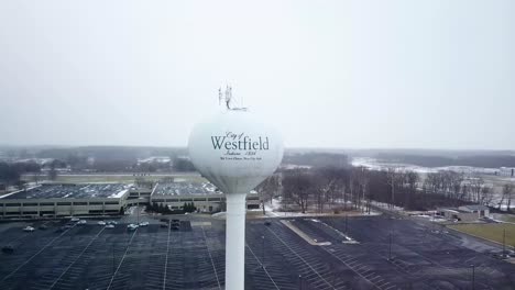 Aerial-view-of-modern-water-tower-tank-with-white-snow-covered-cityscape