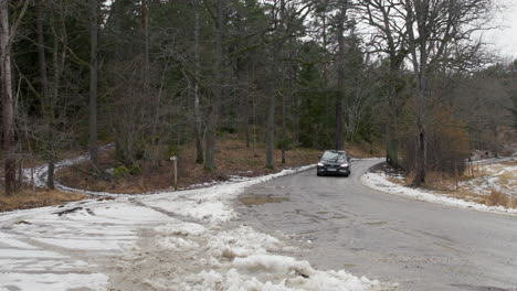 Volvo-S90-Luxury-Sedan-Driving-on-Snowy-Dirt-Road-in-Winter-Forest,-static