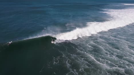 Surfers-attempt-to-ride-large-waves-in-the-shores-of-the-Cocal-Beach-in-La-Libertad,-El-Salvador