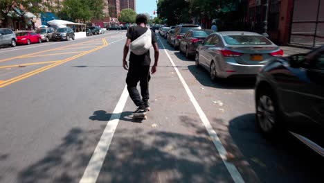 Siguiendo-A-Un-Patinador-Por-Las-Calles-De-La-Ciudad-De-Nueva-York,-Nueva-York,-Hombre-Adulto-Afroamericano