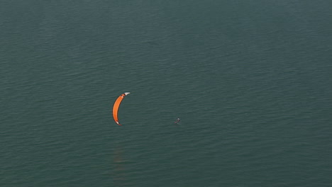 Foilboard-Kiter-Einsam-Im-Blauen-Wasser,-Der-Von-Seinem-Board-Fällt