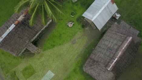 Ascending-aerial-shot,-rotating-while-looking-down-on-huts-in-Kanganaman-Village,-Sepik-Region,-Papua-New-Guinea
