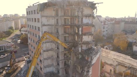 Vista-De-Una-Excavadora-Con-Una-Pluma-Larga-Demoliendo-Un-Edificio-De-Gran-Altura