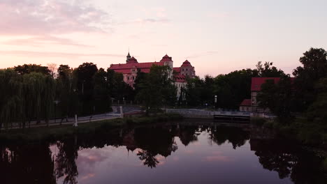 Erhebt-Sich-über-Stillem-Wasser,-Das-Wolken-Reflektiert,-Um-Von-Oben-Auf-Die-Burg-In-Niemodlin-Zu-Blicken