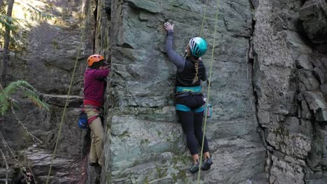 Rock-Climbers-Climbing-Up-Rock-Formation-In-Whitefish,-Montana,-USA---tilt-up-shot