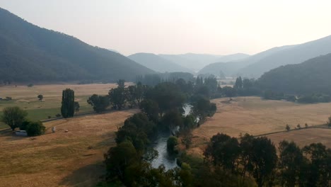 Drone-flies-over-Tumut-River,-Australia-during-bushfire,-December-2019