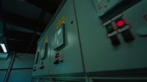 Close-up-of-industrial-control-panels-with-illuminated-buttons-and-meters