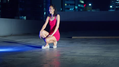 With-the-Caribbean-city-lights-of-Port-of-Spain,-Trinidad-in-the-background,-a-Hispanic-girl-stands-on-a-rooftop