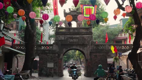 Linternas-Y-Banderas-De-Colores-Decoran-La-Antigua-Puerta-De-O-Quan-Chu-O-Ng-En-El-Casco-Antiguo-De-Hanoi