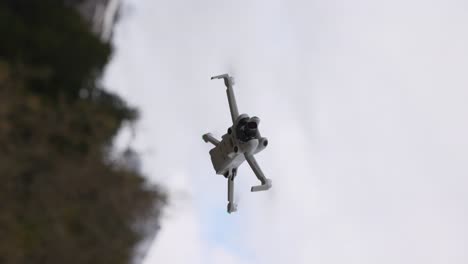 Vertical-footage-of-DJI-Mini-4K-drone-flying-up-into-the-sky