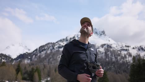 Drone-pilot-launches-mini-drone-from-hand-outdoors-with-Swiss-mountains-in-background