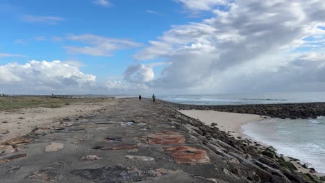 Malerische-Aussicht-Auf-Die-Felsige-Küste,-Sanfte-Wellen,-Wunderschönen-Himmel-Und-Einen-Biker-Auf-Einem-Fahrrad-In-Praia-Do-Furadouro,-Ovar,-Portugal