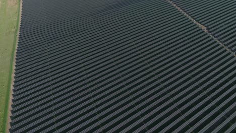 Expansive-solar-farm-in-a-rural-landscape-on-a-sunny-day,-aerial-view