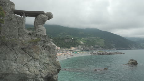 II-Gigante-statue-in-Monterosso-al-Mare,-Italy-on-a-cloudy-day-and-showing-the-Liguria-Sea-with-drone-video-moving-up-and-around