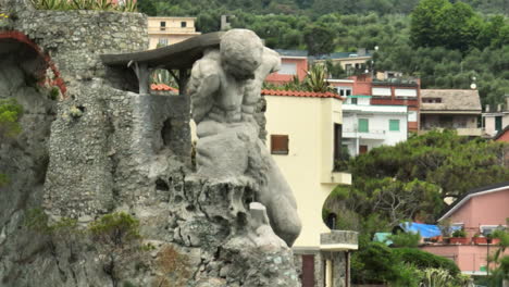 II-Gigante-statue-in-Monterosso-al-Mare,-Italy-on-a-cloudy-day-and-showing-the-Liguria-Sea-with-drone-video-moving-up-with-parallax