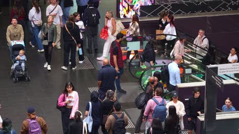 Shoppers-and-commuters-taking-the-escalators-up-and-down-at-Melbourne-Central-Station,-a-shopping-and-commercial-precinct-in-downtown,-slow-motion-shot-showcasing-hustle-and-bustle-of-urban-lifestyle