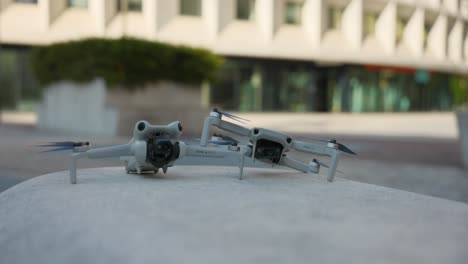Two-mini-DJI-camera-drones-side-by-side-outdoors,-product-comparison-shot