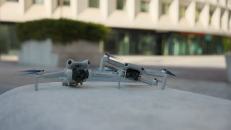 Zwei-Mini-DJI-Kameradrohnen-Nebeneinander-Im-Freien,-Produktvergleichsaufnahme